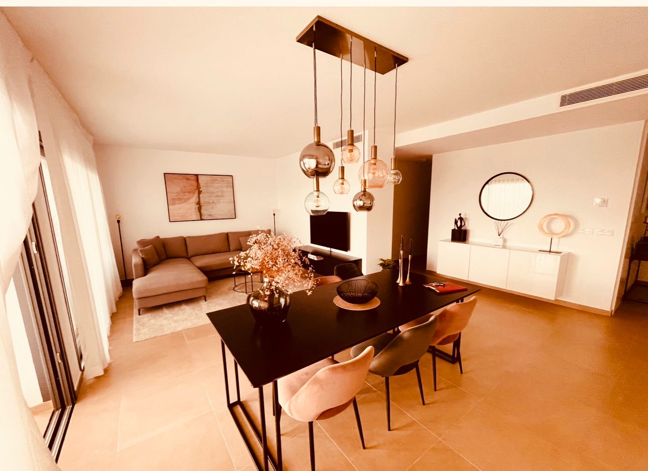 Intérieur moderne et chaleureux d'un appartement avec salon, salle à manger et lumière naturelle, décoration élégante.