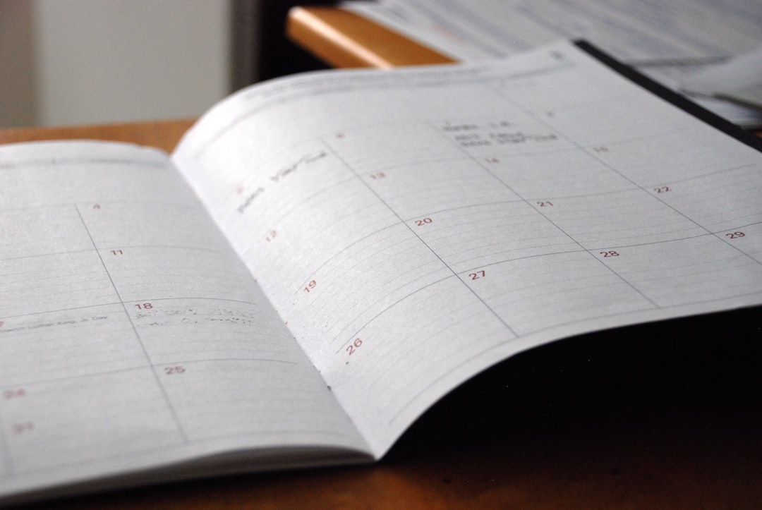Un calendrier ouvert sur un bureau, montrant des dates planifiées et des notes manuscrites.