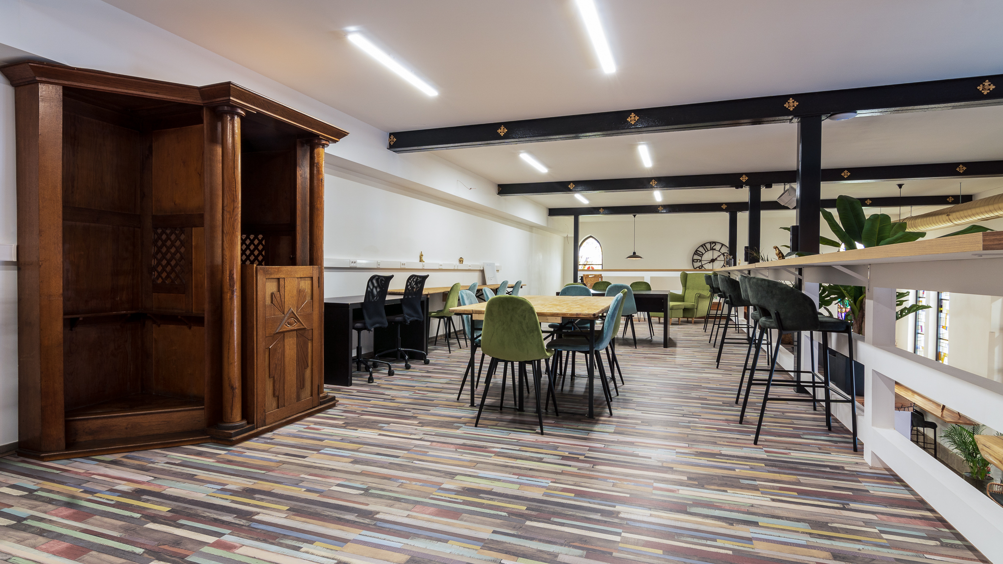 Espace de coworking lumineux avec tables modernes, chaises colorées et un coin salon confortable, ambiance chaleureuse.