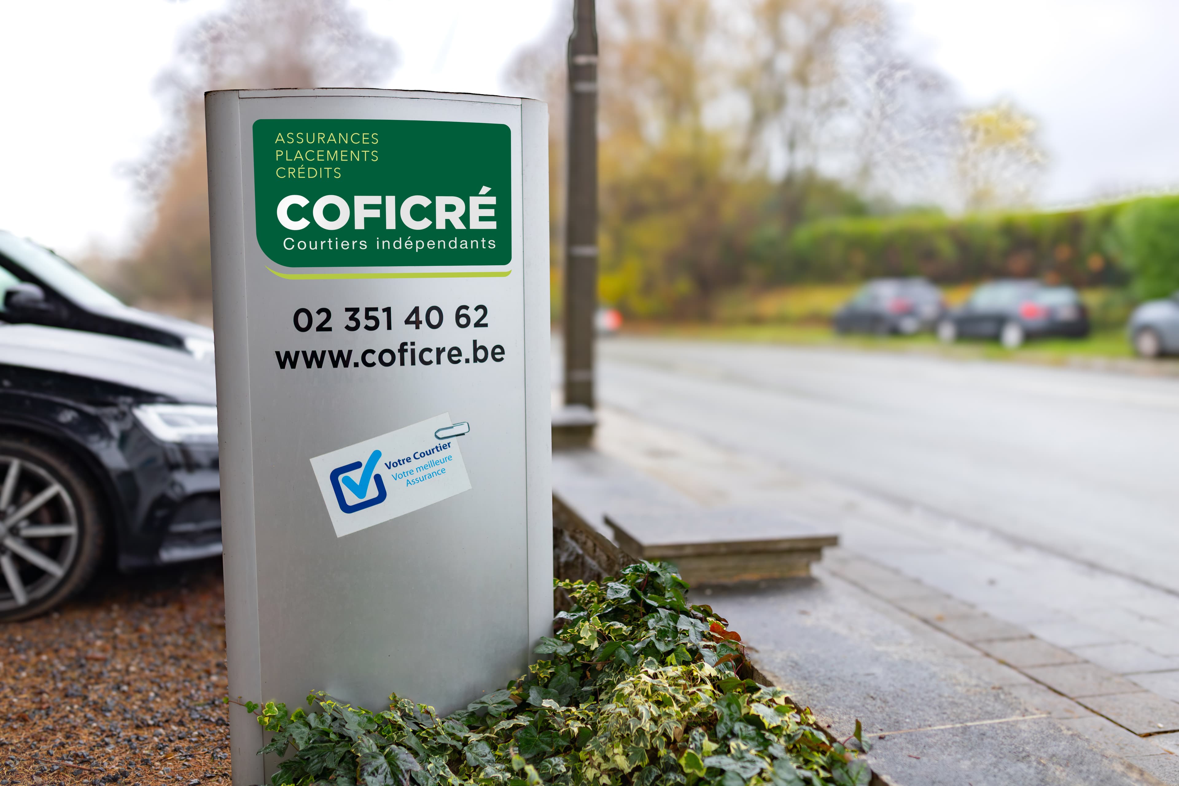 Panneau d'affichage de Coficré, courtier indépendant en assurances, avec logo et informations de contact sur une rue.