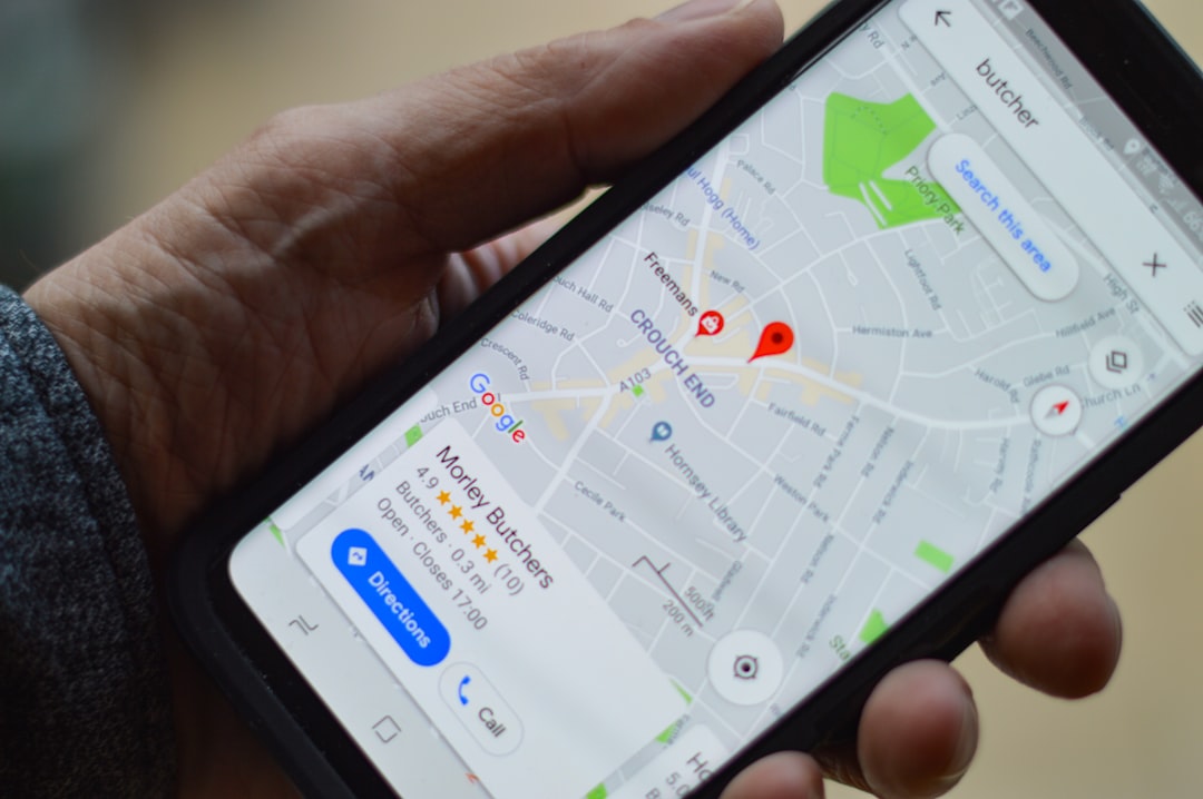 Écran de smartphone affichant une carte avec un point d'intérêt marqué, représentant un commerce local. Lumière naturelle, image en couleurs.