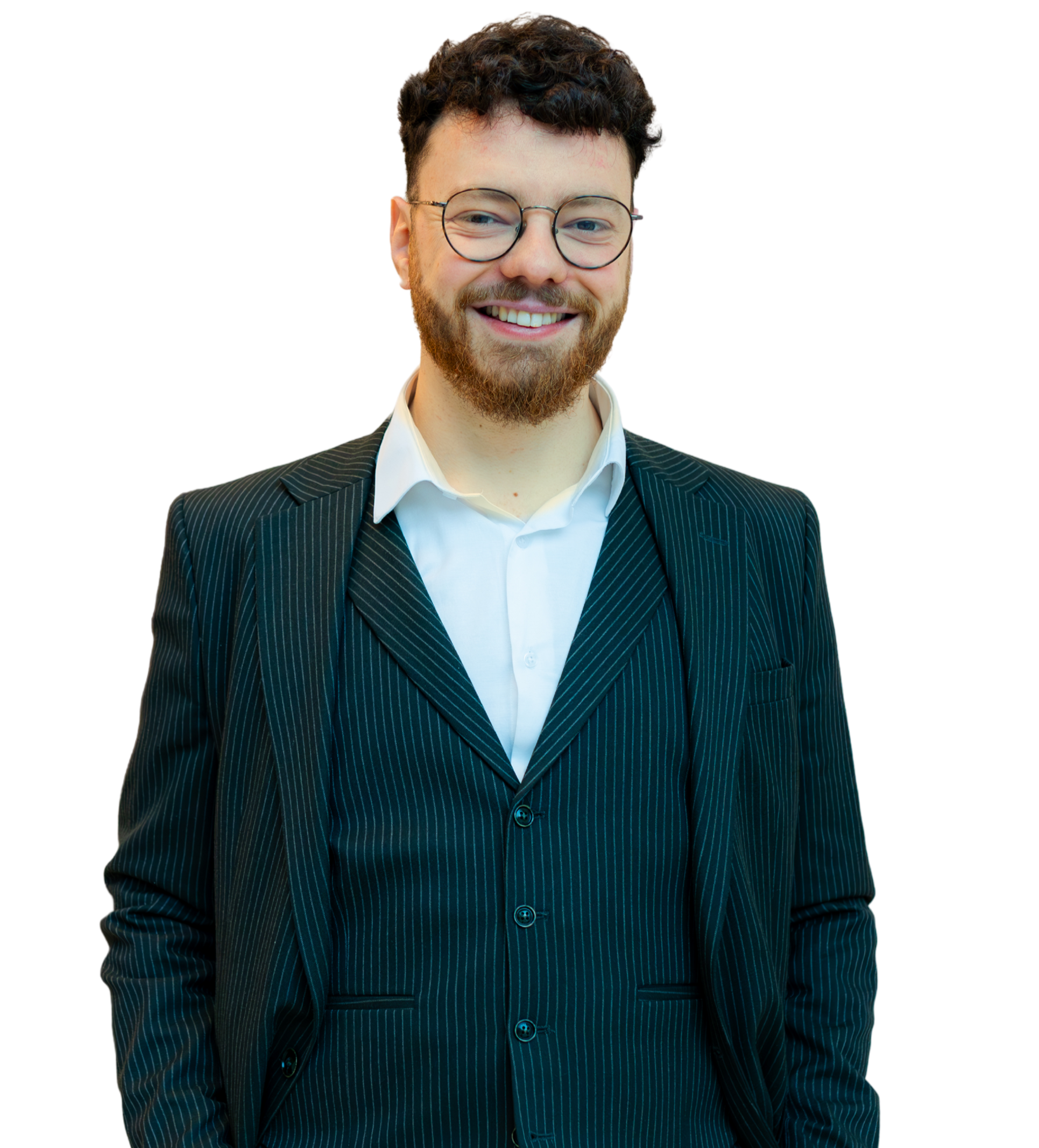 Un homme souriant portant un costume rayé et des lunettes, se tenant debout sur fond neutre.